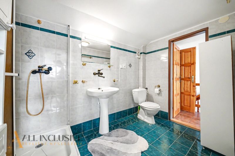 A bathroom with white tiles and turquoise flooring in a family house.