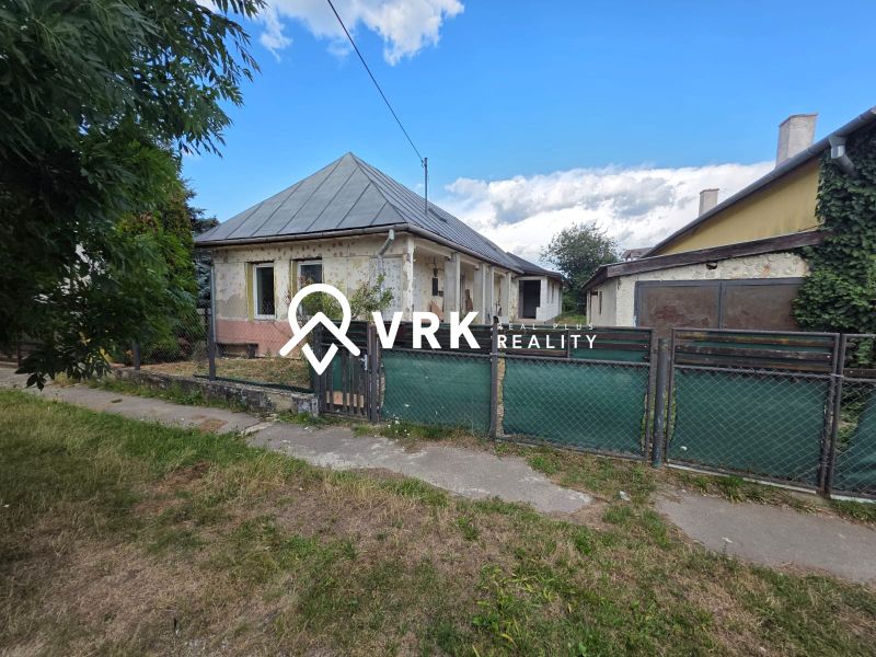 A family house in Kokšov-Bakša with a metal roof, fence, and porch.