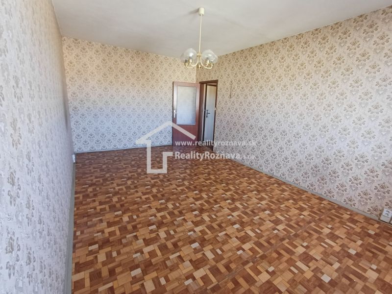 Wallpaper with a floral pattern and a floor with a wooden design in a studio apartment.