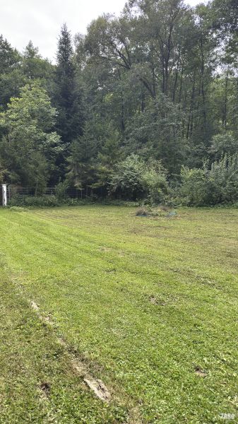 A lawn surrounded by forest near the cottages in Šugovská Valley, Medzev.