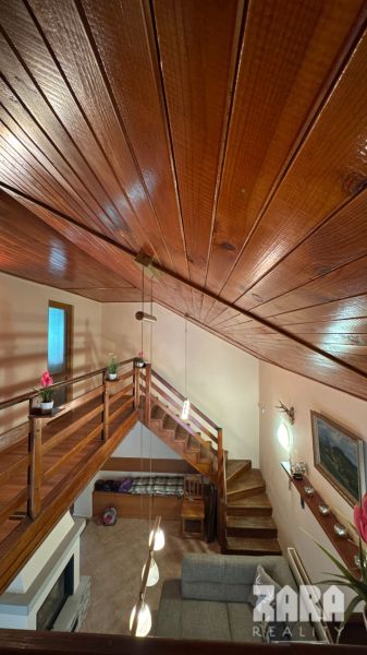 Wooden ceiling and staircase in the interior of the cabin with a floor featuring a wooden decor.