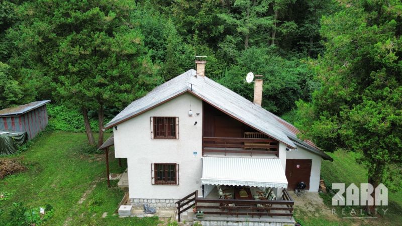 A cottage in the Šugovská Valley in Medzev, surrounded by forests and green trees.