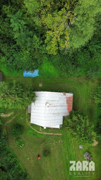 A cottage in the Šugov Valley, Medzev, surrounded by greenery and forest environment.