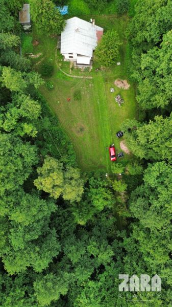 A cottage in the Šugov Valley, Medzev, surrounded by forest and a large green garden.