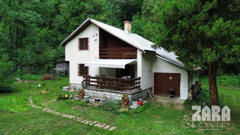 A cottage in nature in the Šugovská Valley in Medzev surrounded by trees and greenery.