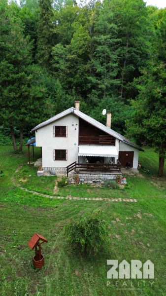 A cottage in the Šugov Valley in Medzev, surrounded by greenery and trees, in a peaceful environment.