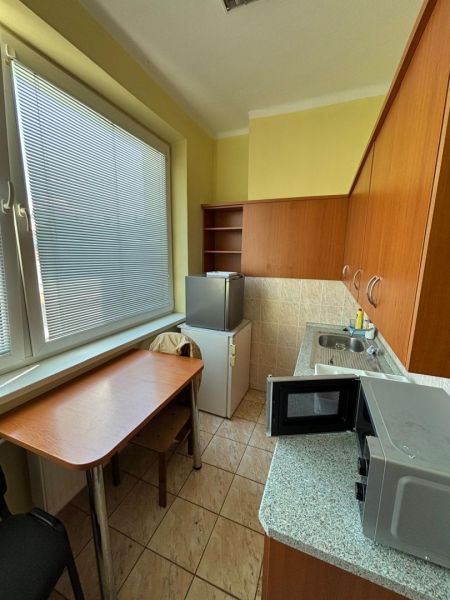 Kitchen in the office with a microwave, table, and fridge.
