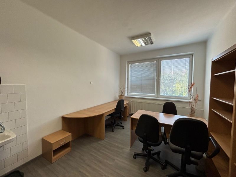 Offices with wood-patterned flooring, desks, and office chairs.