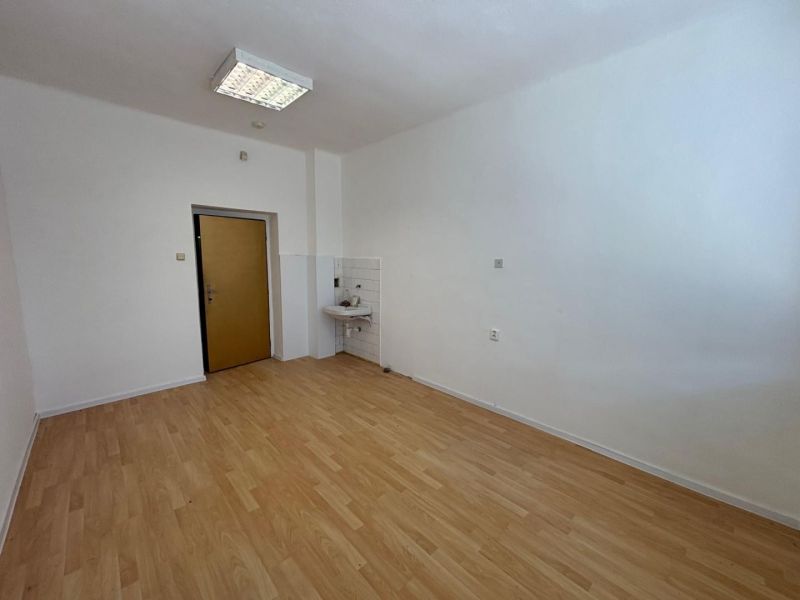 Offices with wood-patterned flooring, a sink, and white walls.