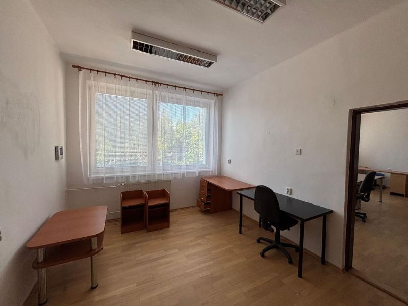 A simple office with furniture and flooring featuring a wood decor.