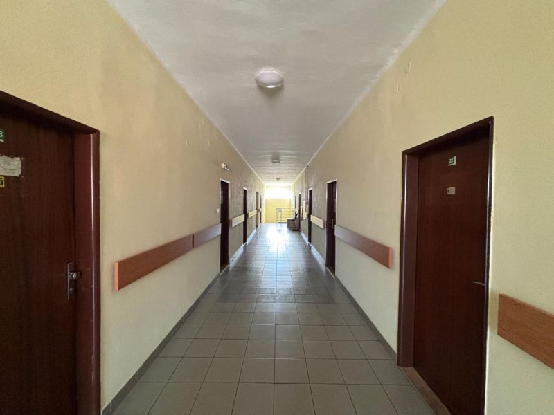 A corridor with tiles and wooden paneling in the interior of offices.