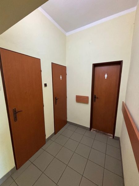 Offices with three marked doors and tiled flooring.