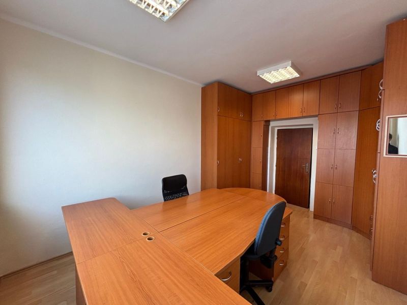Office with desks and storage space, floor with wood decor.