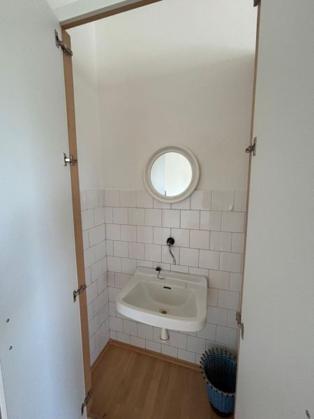 Bathroom with a mirror, sink, and floor with wood decor.