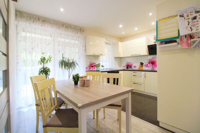 A kitchen in a family house with a dining table, chairs, and a wooden decor floor.