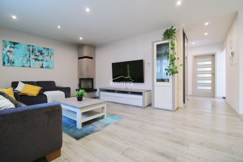 Living room of a family house with a fireplace and a wooden decor floor.