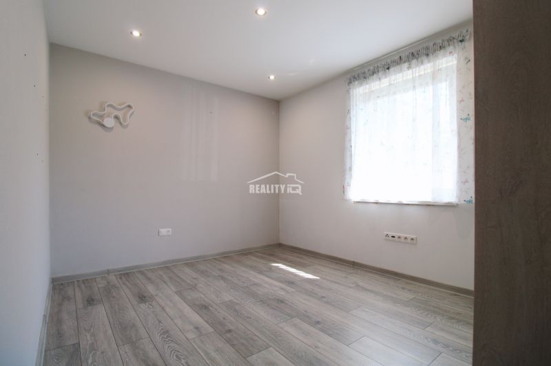 A bright room in a family house with a wooden decor floor and a curtain.
