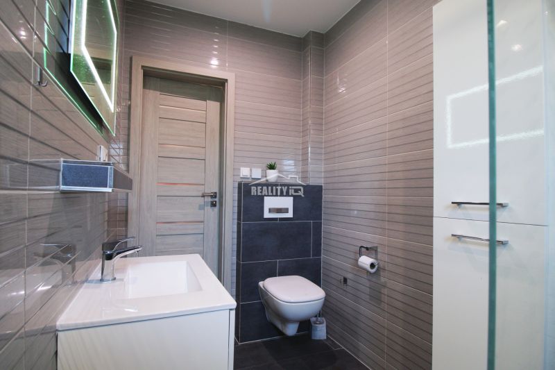 A bathroom with a sink and a mirror in a family house, elegant tiles and accessories.