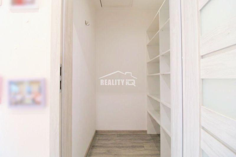 Storage space with shelves and a wooden decor floor in a family house.