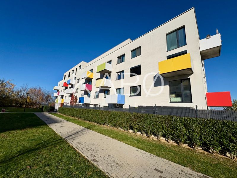 The exterior of the building on Hornostavska in Nitra, colorful balconies and a maintained lawn.