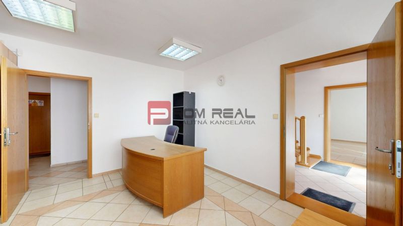 Interior of production facilities with an office desk and tiled flooring.