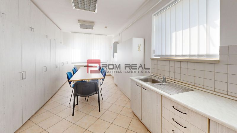 A kitchenette in the production area with a dining table and storage cabinets.