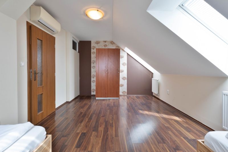 Attic room with wooden decor flooring and skylights in a 2-room apartment.
