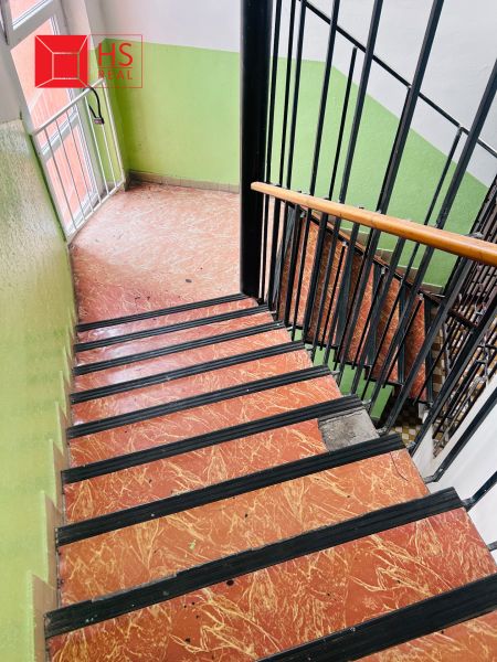 A staircase with a wooden railing and a tiled floor in the offices.