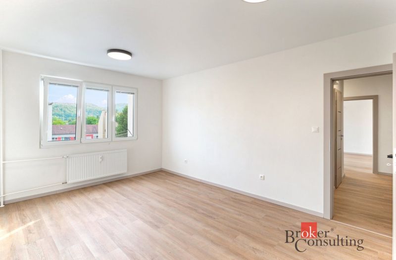 A room with light walls and a wooden decor floor in a 2-room apartment.