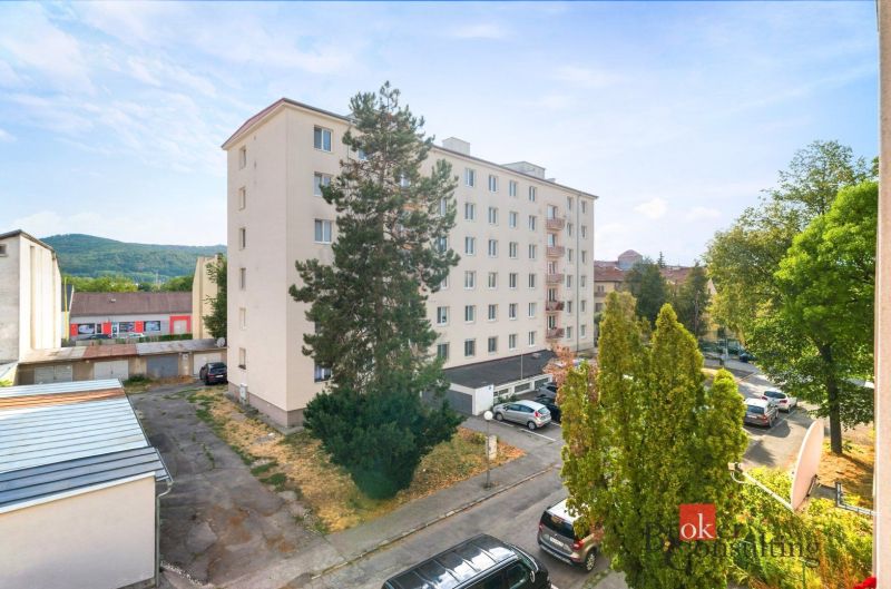 Apartment building surrounded by greenery, Zvolen, Bela IV Street, with parked cars.