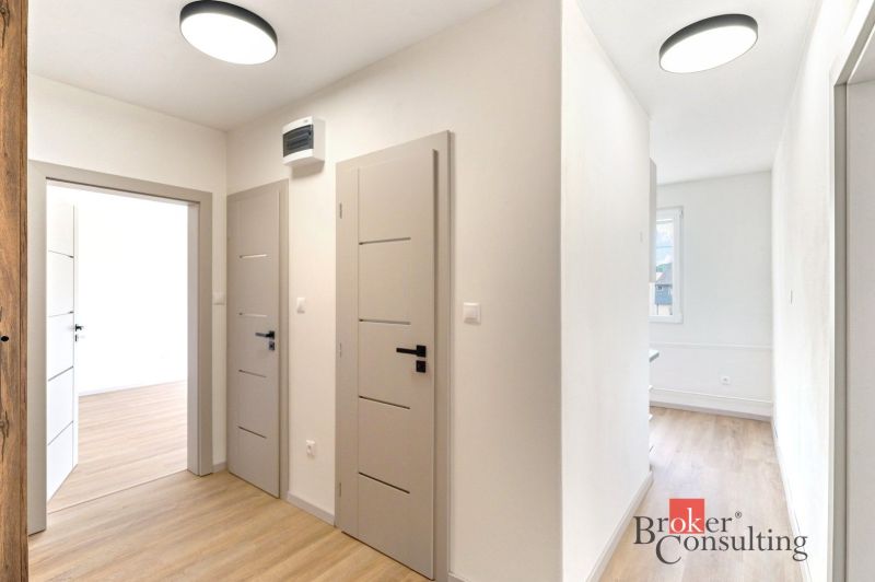 A hallway with doors and a wooden decor floor in a 2-room apartment.