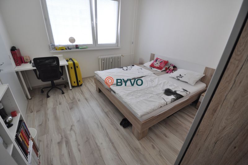 Bedroom with a double bed, a desk, and a floor with a wood decor.