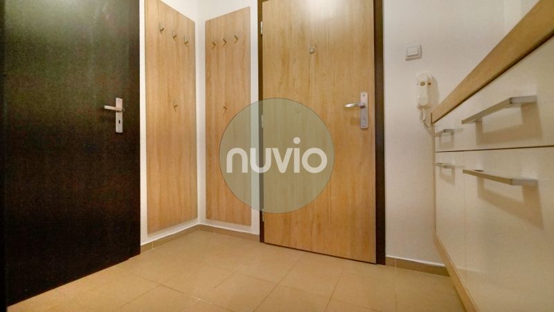 Entrance hallway with wood-patterned flooring and a coat rack in a 3-room apartment.