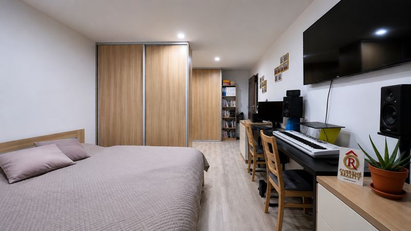 Bedroom in a 3-room apartment with built-in wardrobes, a desk, and a floor with a wooden decor.