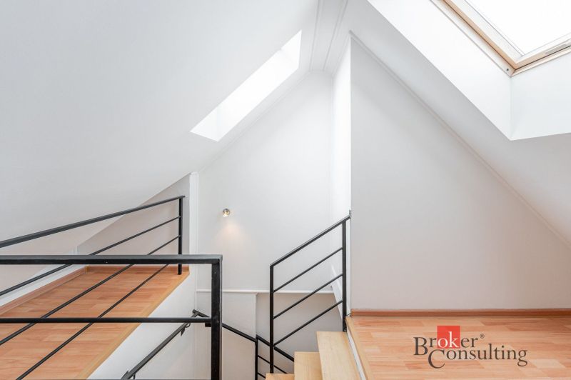 Stairs in a 3-room apartment with a wooden decor floor and large skylights.