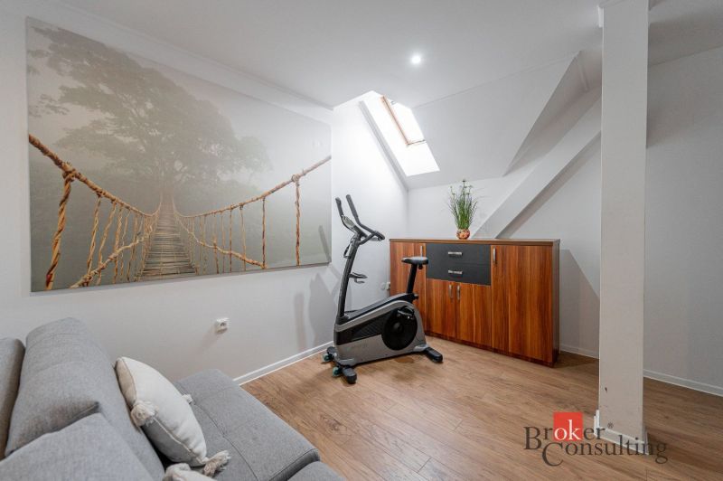 A strengthening corner in the room with a wooden decor floor and a skylight.
