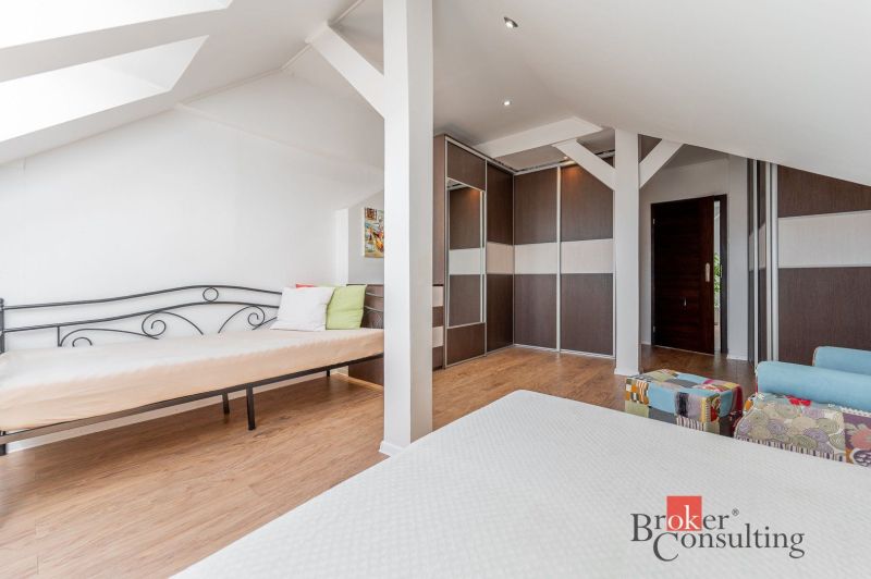A bright room in a 3-room apartment with a wood-patterned floor, a bed, and storage space.