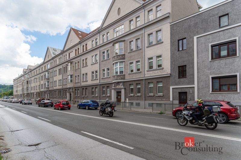 Palackého Street in Košice-Juh with historic buildings, cars, and a motorcyclist.