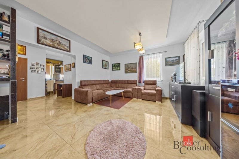 Living room in a family house with a comfortable sofa set and tiled floor.
