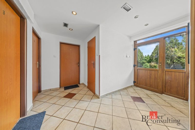 Entrance hallway of a family house with three doors and tiled floor.