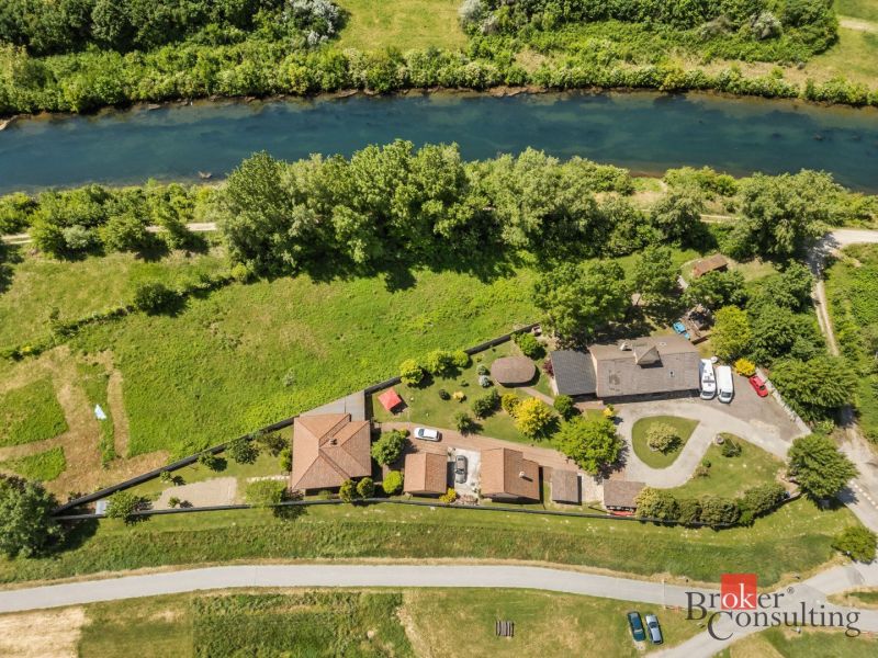 Aerial view of a family house by the river in Hamuliakovo surrounded by greenery.