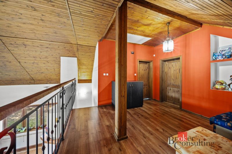 A hallway with a wooden decor floor and orange walls in a family house.