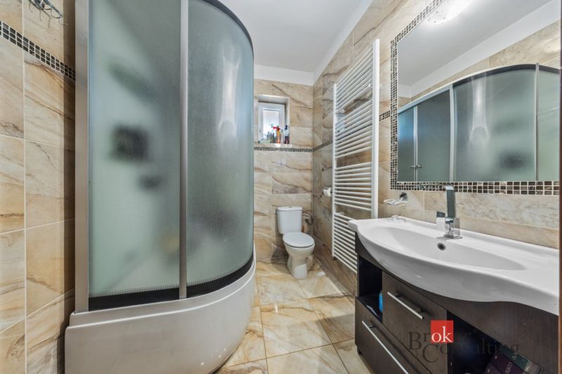A bathroom with a bathtub, sink, and toilet with tiling in a family house.