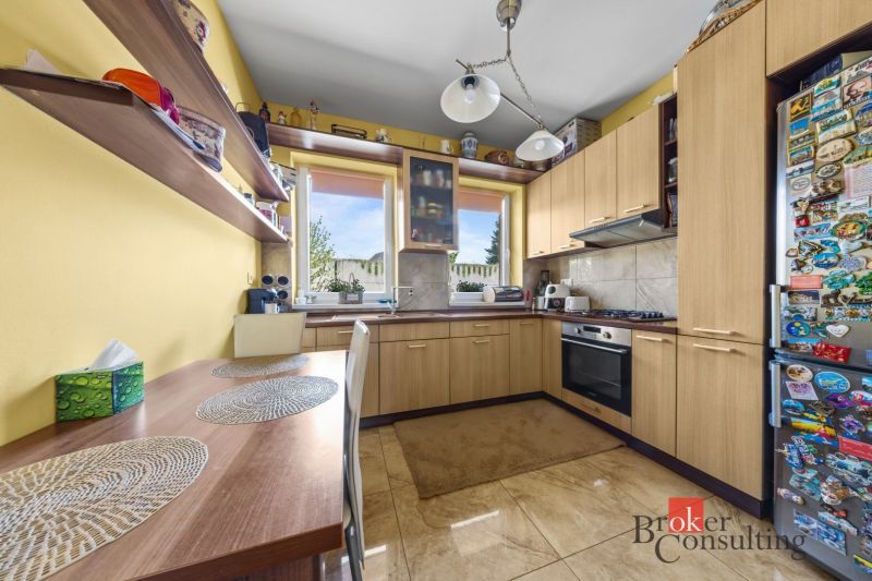 A kitchen in a family house with wooden decor, yellow walls, and a built-in appliance.