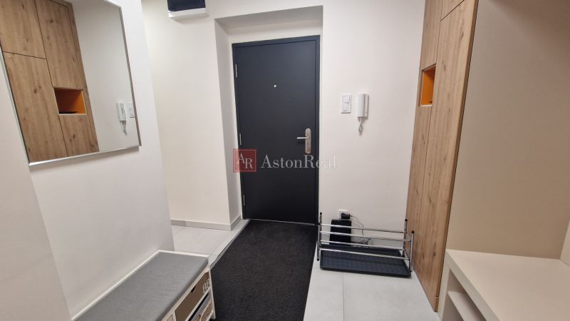 A hallway with black doors, a wardrobe with wooden decor, and a mirror in a 3-room apartment.