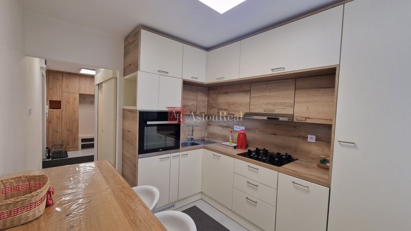 A kitchen in a 3-room apartment with a wooden decor and built-in appliances.