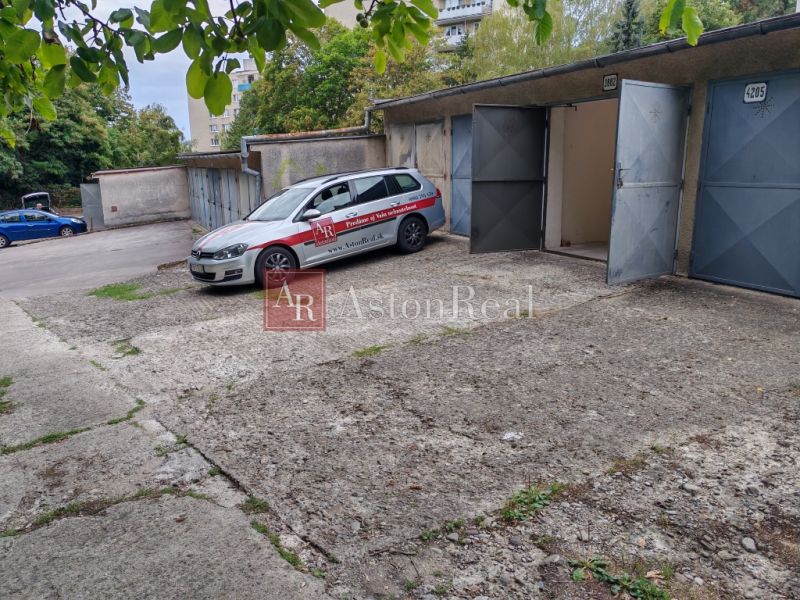 Garages on Partizánska Street in Trenčín with a parked car and an open garage.