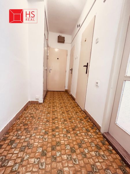 Hallway in a 2-room apartment with tiles and white walls.