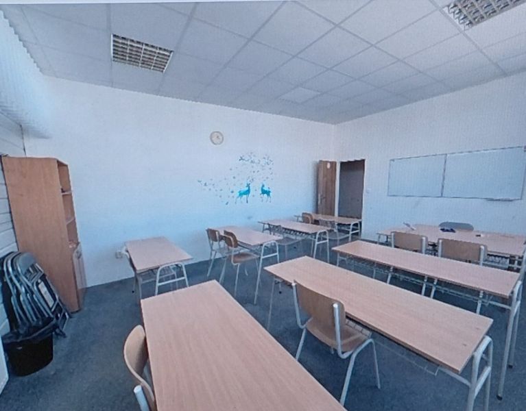 Classroom with desks, chalkboard, and wall decoration in the Offices.