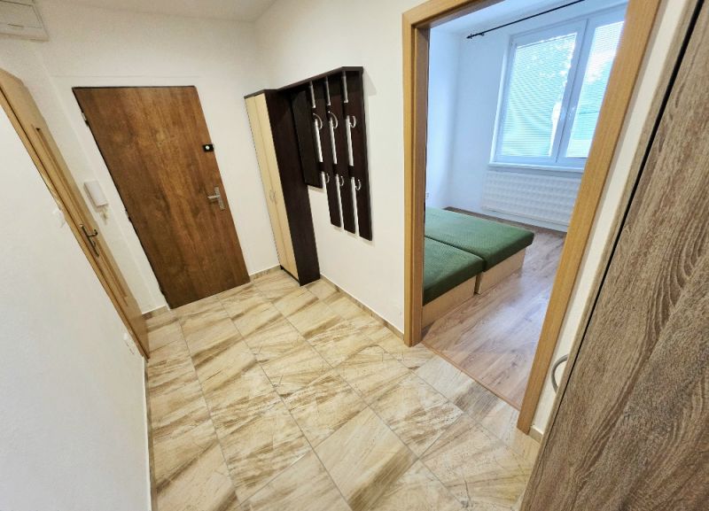 The entrance hall of a 3-room apartment with coat racks and a view into the bedroom.